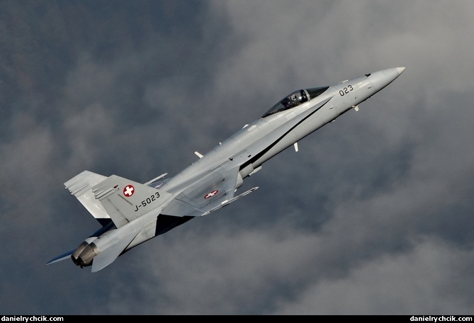 F/A-18C Hornet climbing above low clouds