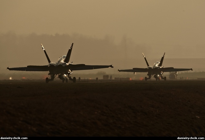 Two F/A-18 Hornets taxiing for an evening mission